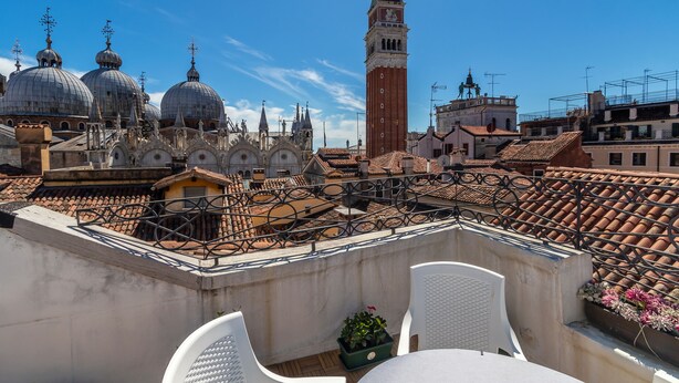 A rooftop terrace with a view of historic buildings, including domes and a tower. - Hotel ai do Mori (Venice)