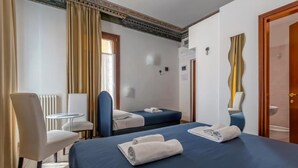 A hotel room with two beds, a chair, a small table, and a bathroom visible through an open door. - Hotel ai do Mori (Venice)