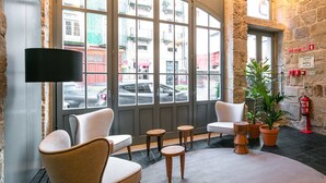 A modern interior with large windows, a flat-screen TV, comfortable seating, and a fire extinguisher. - Porto River Infante (Porto)