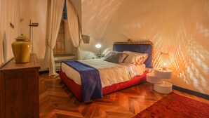 A cozy bedroom with a bed, bedside lamp, and a wooden nightstand.