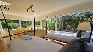 A hotel room with two beds, large windows, a sofa, and a lamp. - MOUNTAIN VIEWS fireplace SPA 5 bedrooms, air-cond, early checkin & late checkout (Wentworth Falls)