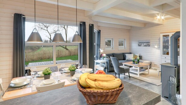 A modern kitchen with a dining area, featuring a large window, wooden ceiling, and a central island with a basket of bananas. - Lovely home in Krems II/Warderbrück with sauna (Krems II/Warderbrück)