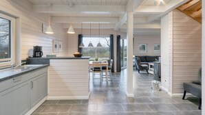 A modern kitchen with a central island, pendant lighting, and a view to the dining area. - Lovely home in Krems II/Warderbrück with sauna (Krems II/Warderbrück)