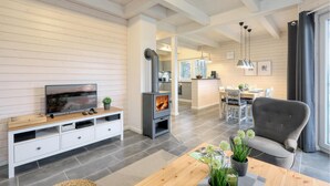 A modern living room with a TV, entertainment system, and a wood-burning stove. - Lovely home in Krems II/Warderbrück with sauna (Krems II/Warderbrück)