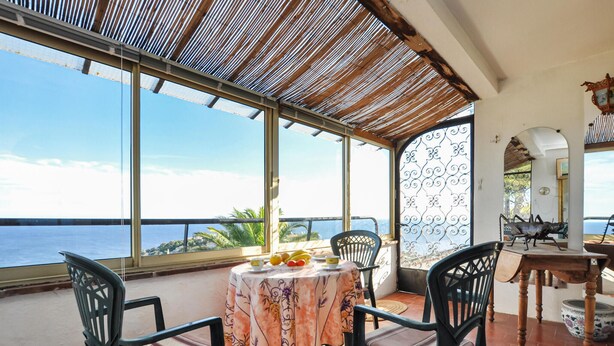 A dining area with a table and chairs, large windows with a view of the sea, and a decorative metal gate. - 2 bedroom stunning home in Roquebrune-sur-Argens (Roquebrune-sur-Argens)