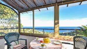A balcony with a table set for two, overlooking a coastal view. - 2 bedroom stunning home in Roquebrune-sur-Argens (Roquebrune-sur-Argens)