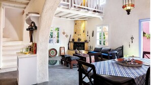 Un ambiente acogedor con zona de comedor, chimenea y habitación en un altillo.