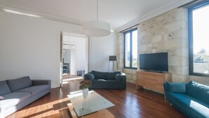 A modern living room with a sofa, a coffee table, and a TV.