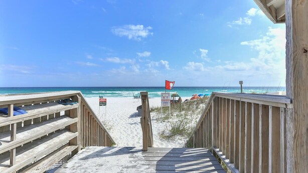 A wooden boardwalk leading to a beach with a red flag indicating private property. - Summer Retreat - Prime Location | Sleeps 8 | Pets (Destin)