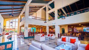 A spacious lobby with multiple seating areas, a bar, and a restaurant. - Marina Wadi Degla Hotel (Ataqah)