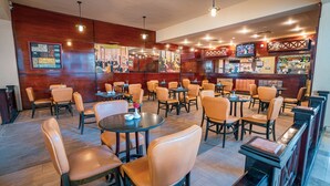 A restaurant with wooden walls, multiple tables and chairs, and a bar area with a television. - Marina Wadi Degla Hotel (Ataqah)