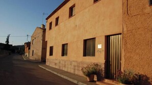 A two-story building with a beige facade, a visible door labeled "Rai 2", and potted plants on the ground floor. - 4 bedroom house (Caravaca de la Cruz)