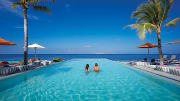 Una piscina al aire libre, sillones reclinables de piscina