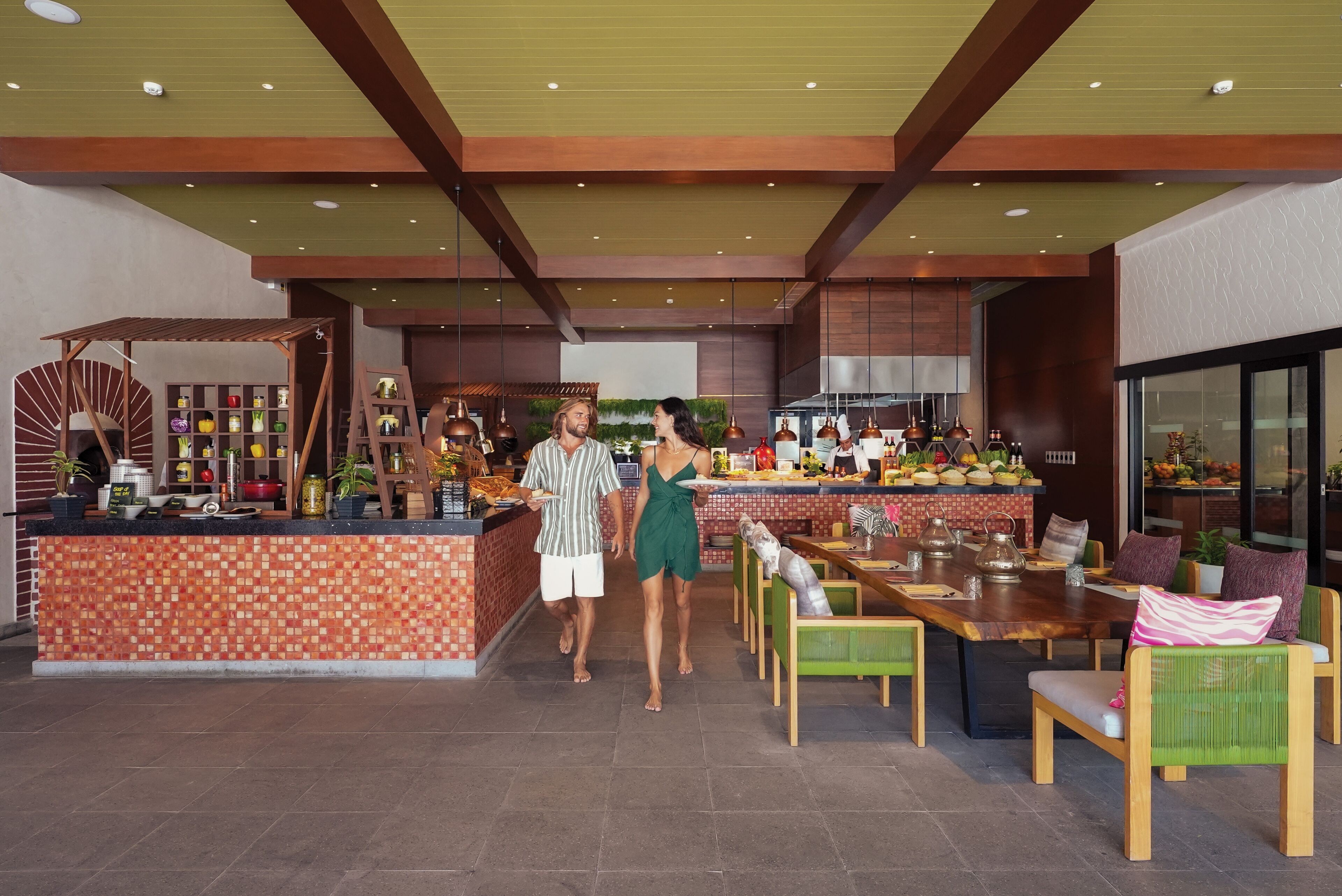 A modern restaurant interior with a tiled bar area, wooden furniture, and a variety of decorative items.