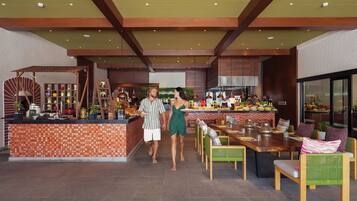 A modern restaurant interior with a tiled bar area, wooden furniture, and a variety of decorative items.