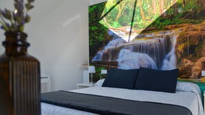 Camera da letto con un letto, un comodino, una lampada e un condizionatore d'aria a parete.