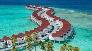 An overwater resort with a continuous walkway connecting multiple bungalow-style accommodations.