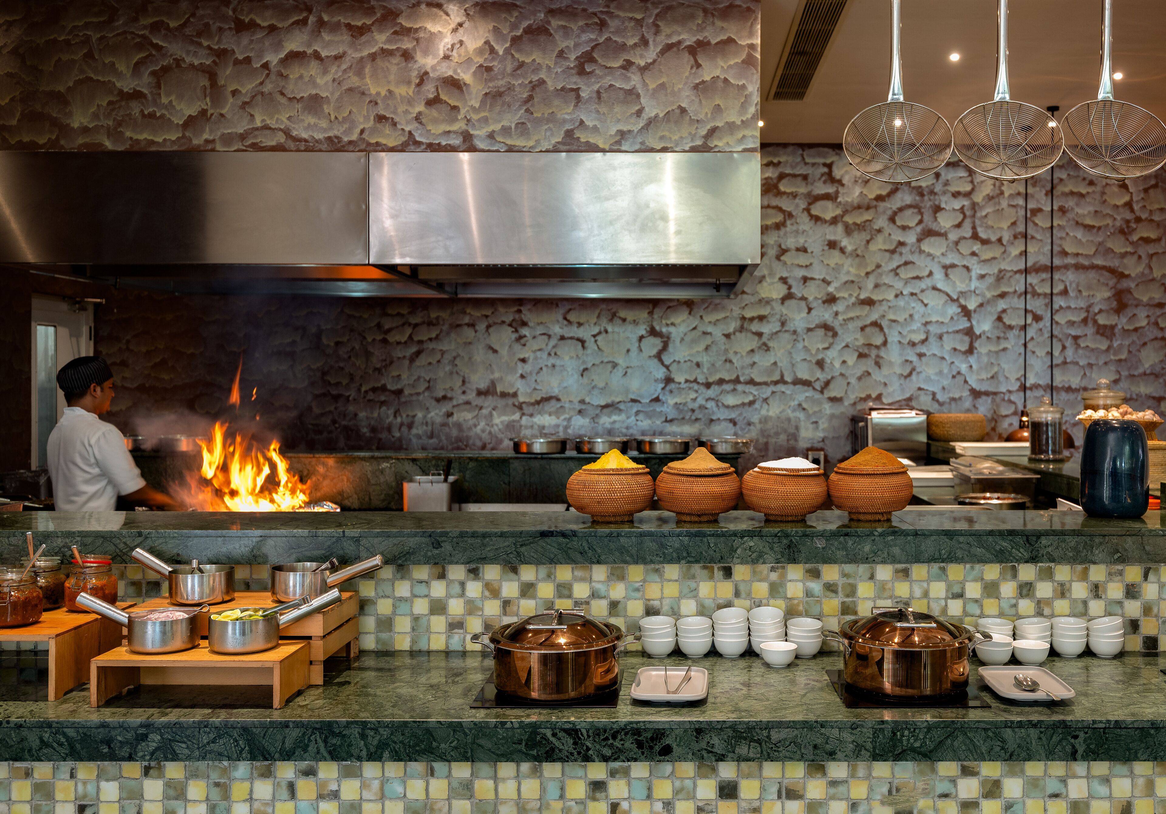 Une cuisine dotée d’une grande cuisinière, de casseroles et d’un plan de travail recouvert de carreaux.