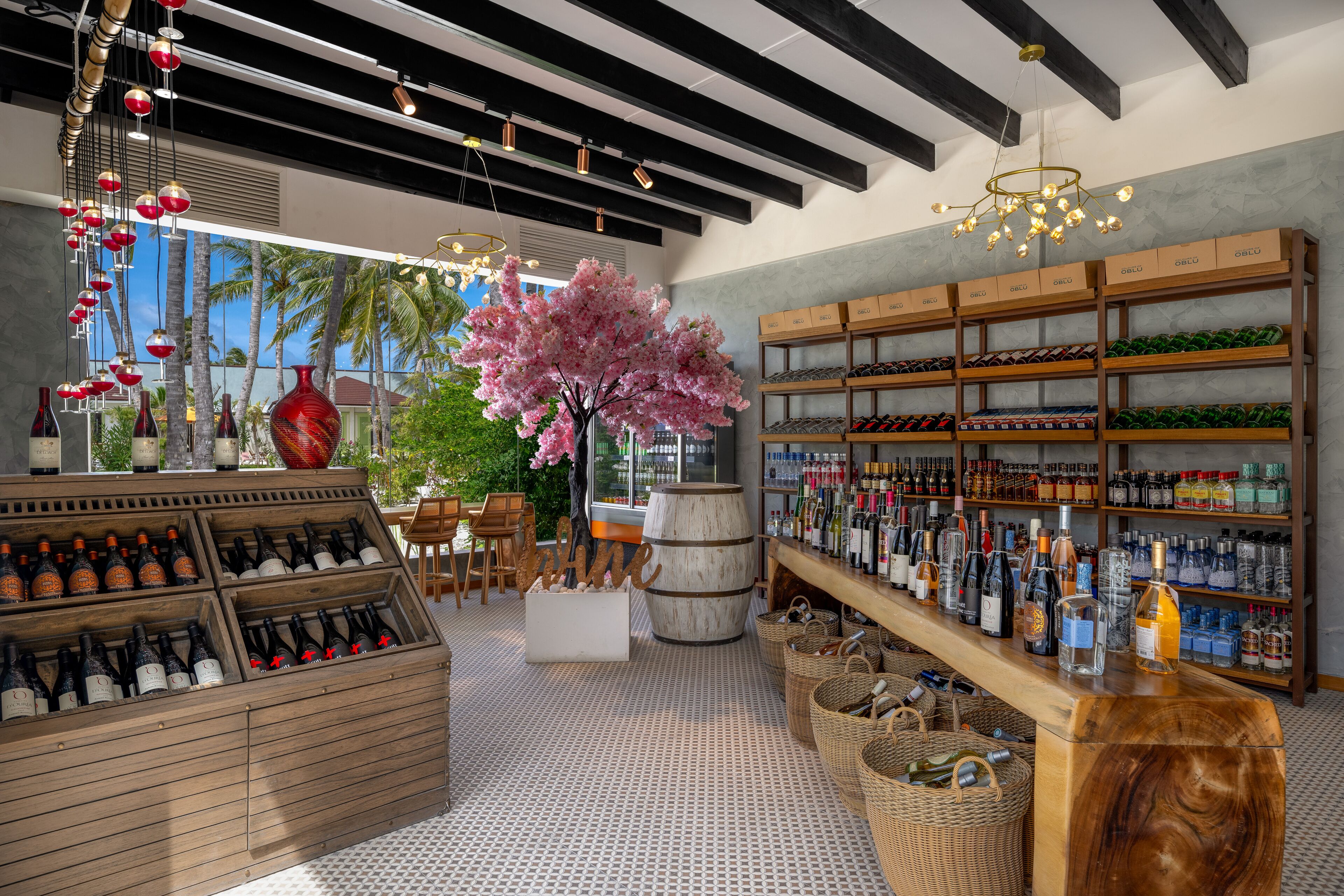 A wine shop with wooden shelves, a large wooden barrel, and a cherry blossom tree.