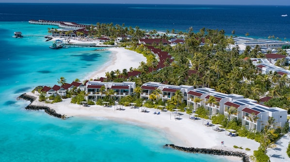 An aerial view of a resort with beachfront villas, a sandy beach, and a pier extending into the ocean. - OBLU XPERIENCE Ailafushi - All Inclusive with Free Transfers (Ailafushi)