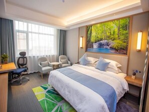A hotel room with a large bed, two armchairs, a desk, and a painting of a waterfall. - Greentree Eastern Hotel Binzhou Zhonghai International Convention and Exhibition Center (Binzhou)