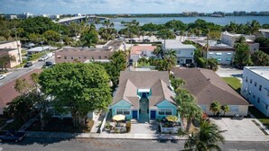 A coastal residential area with a prominent building featuring a blue entrance and a small patio. - Steps to Beach & Downtown! Private Patio & Parking (Lake Worth)