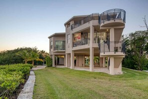 A multi-story house with a covered patio and a balcony.