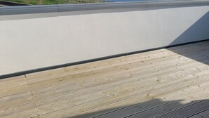 Vista da un balcone su una spiaggia, con cielo sereno.