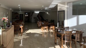 A spacious dining area with wooden furniture and a tiled floor. - KURT OTEL (Trabzon)