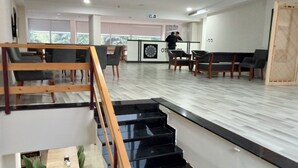 A modern interior with a reception desk, seating area, and a staircase. - KURT OTEL (Trabzon)