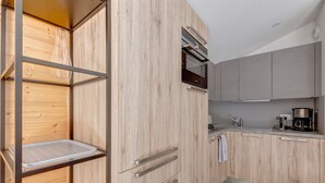 A modern kitchen with wooden cabinetry, a stainless steel range hood, and a built-in oven.