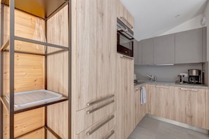 A modern kitchen with wooden cabinetry, a stainless steel range hood, and a built-in oven.
