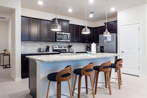 Enjoy cooking in this well-lit kitchen with a central island and stainless steel appliances.