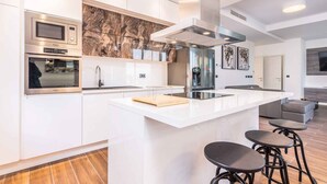 A modern kitchen with a central island, stainless steel appliances, and a marble backsplash. - Villa with private pool, jacuzzi and sauna (Malinska)