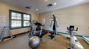 Un gimnasio con cintas de correr, elípticas y pesas sueltas.