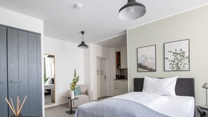 A modern bedroom with a bed, bedside tables, a desk, and a wardrobe. - Limehome Linz Friedrichstraße (Linz)