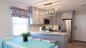 A modern kitchen with white cabinetry, stainless steel appliances, and a central island with seating. - ★GORGEOUS STYLISH APT Close to American Dream & NYC★ (Belleville)