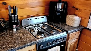Una cucina con piano cottura a gas, mobili in legno e macchina da caffè.
