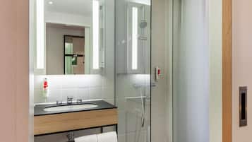 Ein modernes Badezimmer mit einer Duschkabine, einem Holzlagerflansch mit Waschbecken und einem Spiegel darüber.