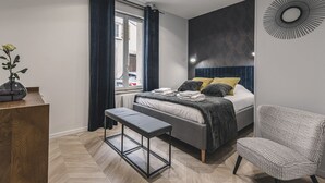 Une chambre à coucher moderne avec un lit, une table de chevet, un banc et une chaise.