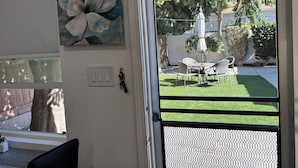 A room with a view of a backyard patio, a painting on the wall, and a door with a screen. - Great WLA location! TWO miles  to FOX Studios 10 miles to UCLA Studio-Furnished (Los Angeles)