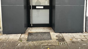 Une porte d’entrée en métal noir, avec une porte vitrée et le chiffre « 40 » peint sur le mur.