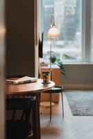 A cozy room with a wooden table, a lamp, and a chair.
