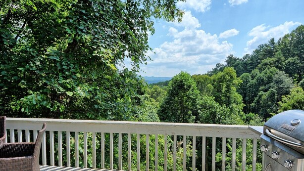 Eine Holzterrasse mit Grill und Korbmöbeln.
