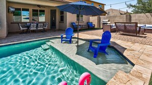 Ein Swimmingpool mit blauen Stühlen und einem pinken Flamingo-Schwimmspielzeug.