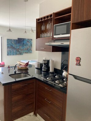 A modern kitchen with a central island, stainless steel appliances, and wooden cabinets.