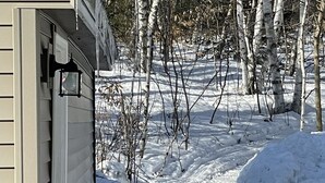 Un chemin enneigé menant à une maison avec une porte de garage.