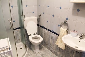 Une salle de bain comprenant des toilettes, un lavabo et une douche à parois en verre.