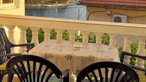A balcony with a table and chairs overlooking a coastal landscape. - Apartment in Tribunj with Seaview, Balcony, Air condition, WIFI (5035-2) (Tribunj)