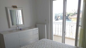 A bedroom with a bed, a dresser, a mirror, and a sliding glass door leading to a balcony. - Apartment in Tribunj with Seaview, Balcony, Air condition, WIFI (5035-2) (Tribunj)